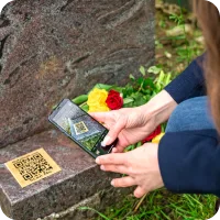 Scanning a QR plaque at a graveside
